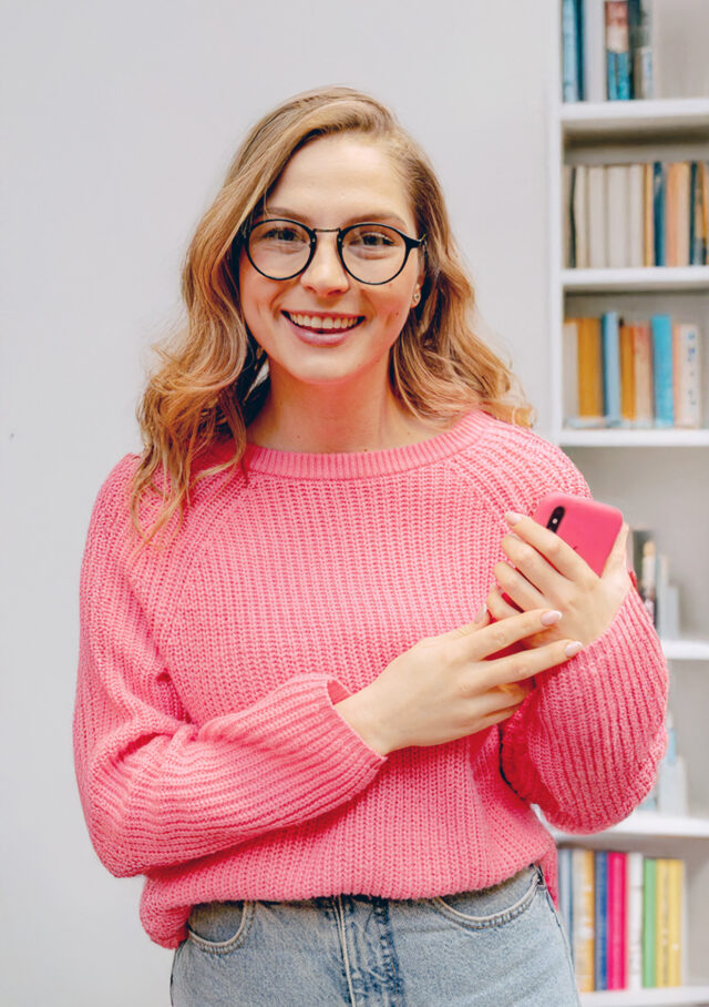 Junge Frau mit Smartphone in der Hand