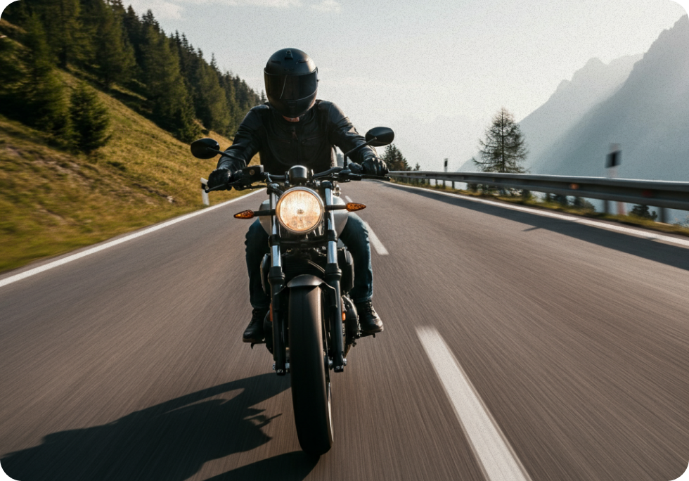Ein Motorrad fährt auf einer Bergstraße. Der Fahrer trägt Handschuhe und einen schwarzen Helm.